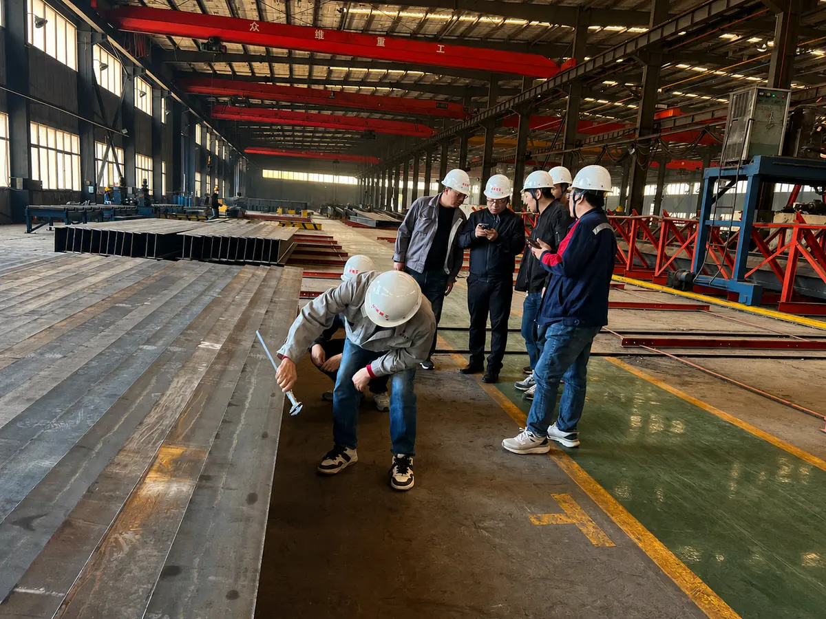 Main contractor inspectors checking fabricated H-section members in the Zhongwei workshop
